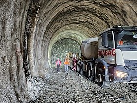 Concrete mixer truck, construction equipment and site personnel inside the Gladnijci Tunnel during ongoing construction works