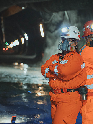 Two workers with protective masks in a tunnel