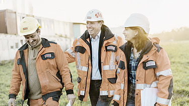 Two men and a woman from the engineering team on a meadow