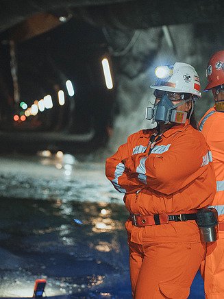 Two workers with protective masks in a tunnel