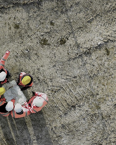 Bird's eye view photo of construction workers around a construction plan