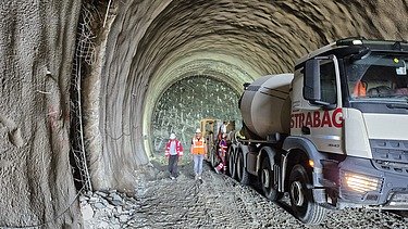 Concrete mixer truck, construction equipment and site personnel inside the Gladnijci Tunnel during ongoing construction works