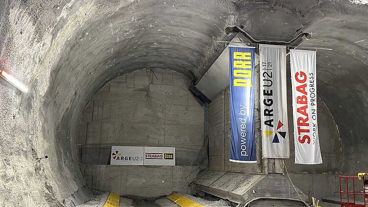 Underground tunnel section of Vienna's U2 metro extension with construction area, concrete lining and project banners inside the excavation cavern