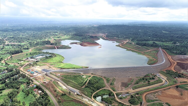 Aerial view of a large-scale dam and reservoir project in Kenya, featuring the dam structure, water storage area and associated infrastructure.