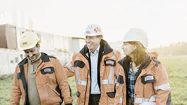 Two men and a woman from the engineering team on a meadow