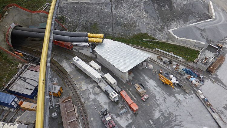 Luftaufnahme einer Großbaustelle mit Rohrvortriebssystem, Transportleitungen und Baustelleneinrichtung für den Bau unterirdischer Wasserinfrastruktur.