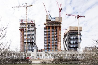 High-rise residential buildings TrIIIple with four construction cranes