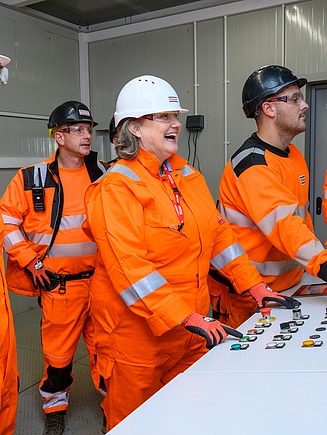 Workers and engineers in front of a control panel