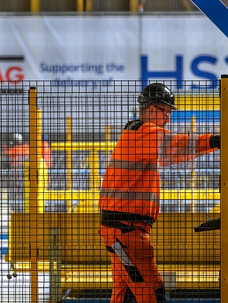 Workers behind a construction grid